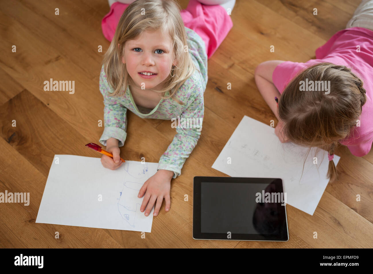 Deux soeurs avec tablette numérique et de feuilles de papier sur marbre Banque D'Images