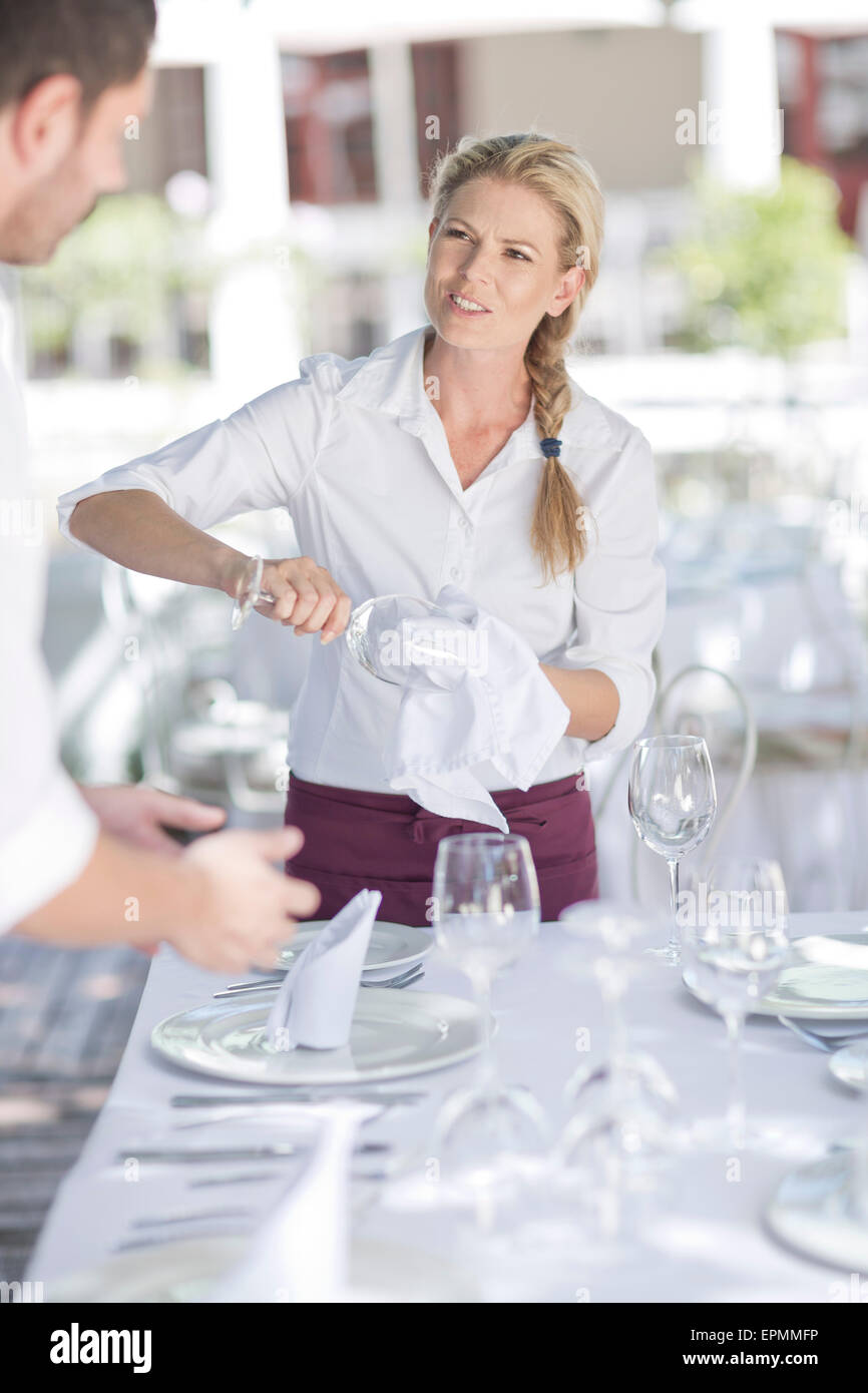 Serveurs mise en place d'une table de restaurant Banque D'Images
