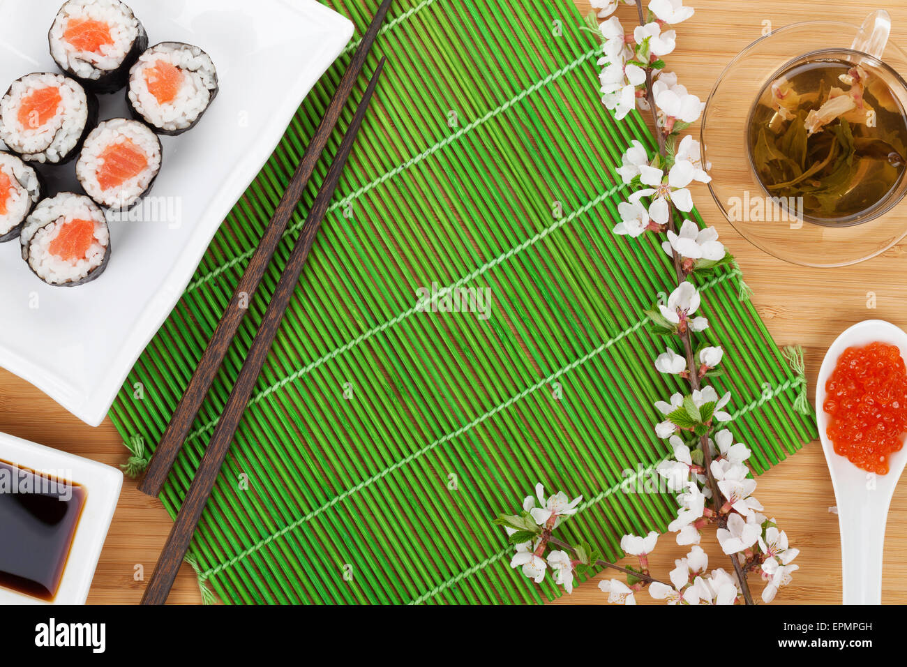 Sushi maki set, thé vert et sakura branche sur table en bambou avec copie espace Banque D'Images