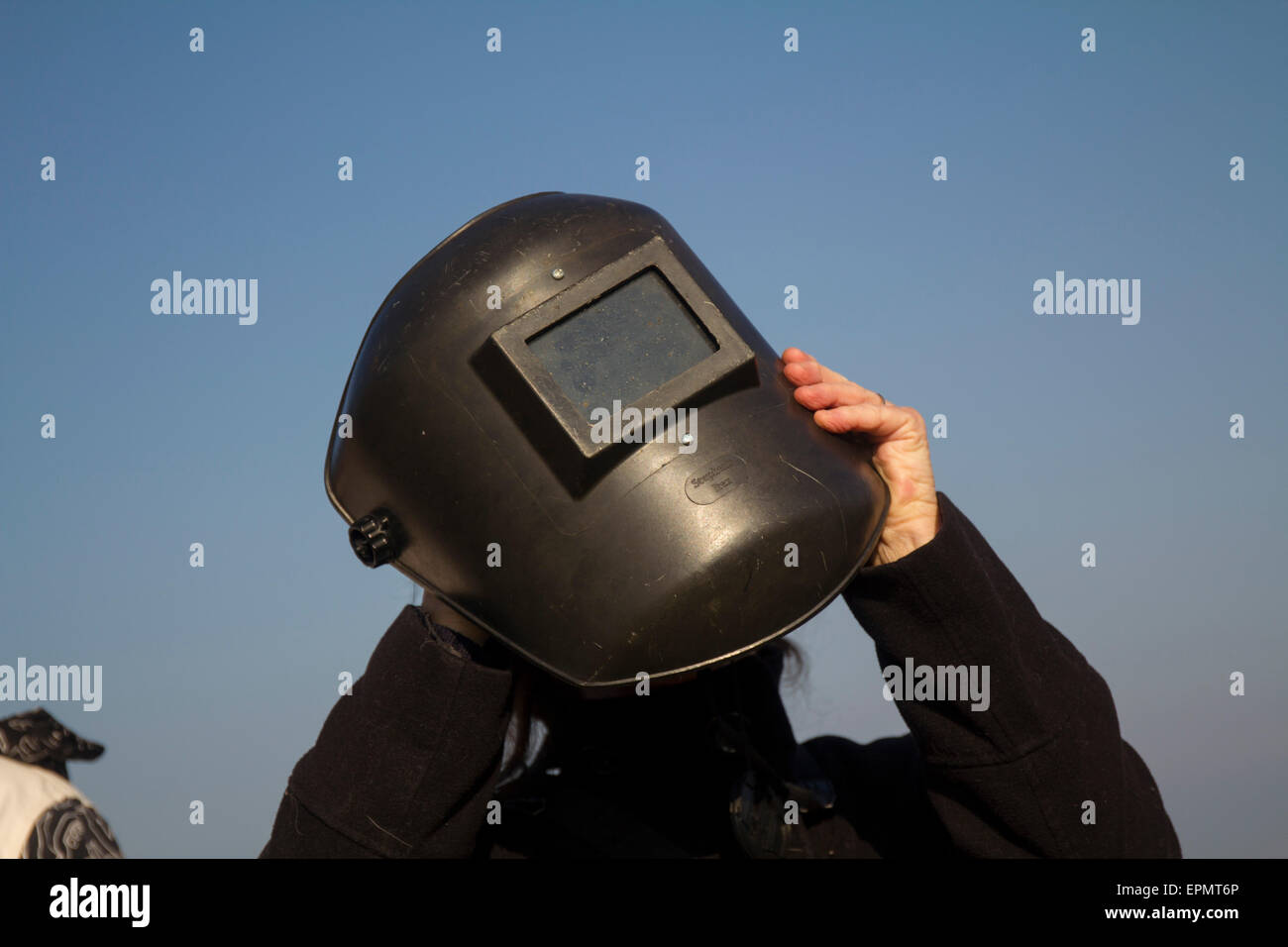 Femme à l'aide d'un masque de soudeur pour protection des yeux tout en regardant l'specacular éclipse solaire partielle, le 20 mars, 2015, sur moorlan Banque D'Images