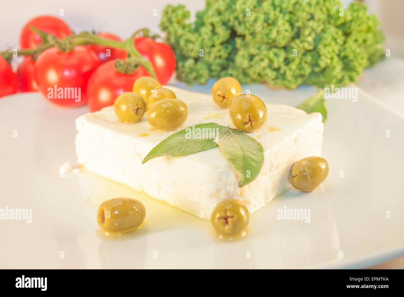 Feta et olives vertes, en face de tomates et de chou vert Banque D'Images