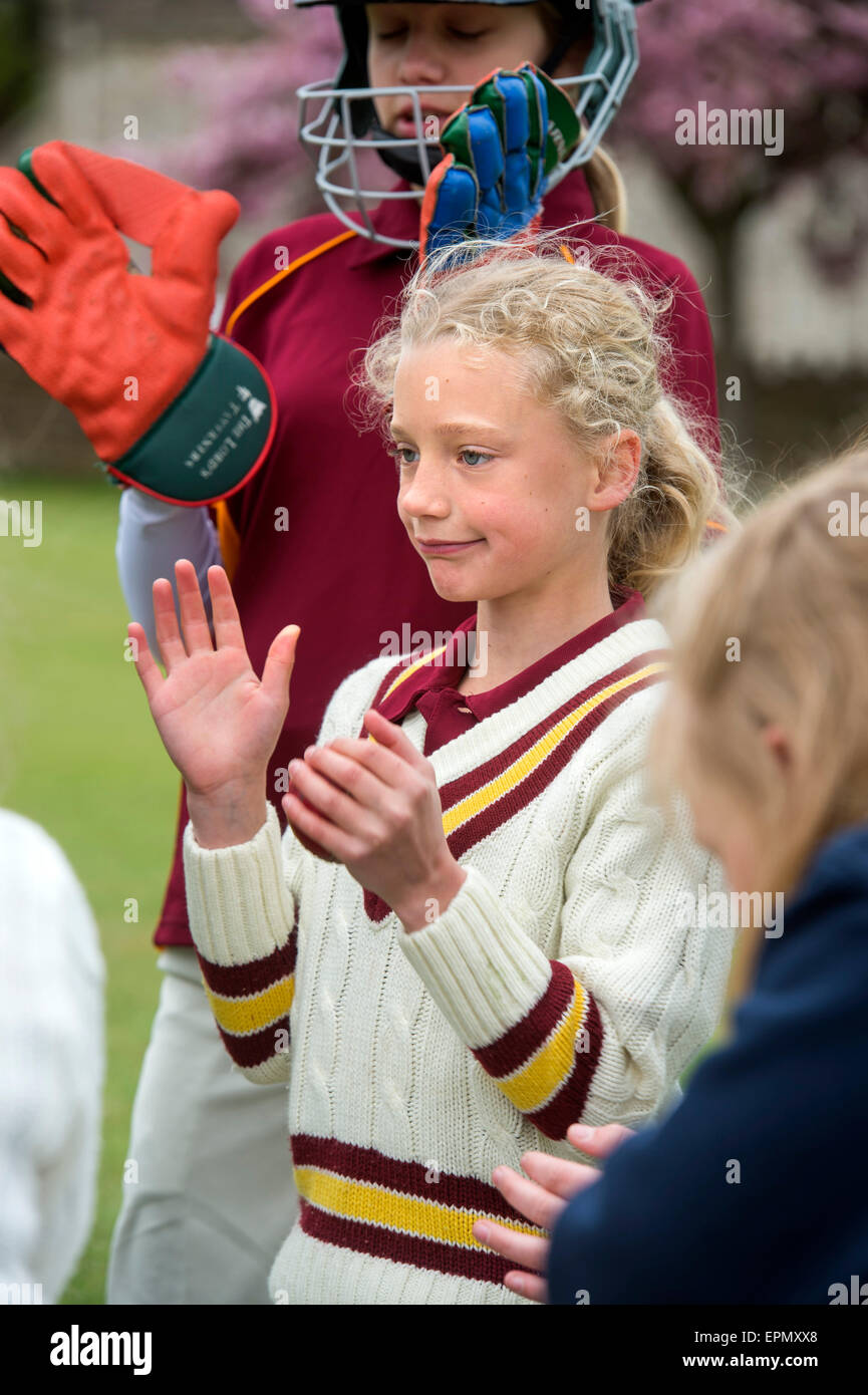 Junior Filles célèbrent en tenant un guichet pendant un match de cricket dans le Wiltshire, Angleterre Banque D'Images