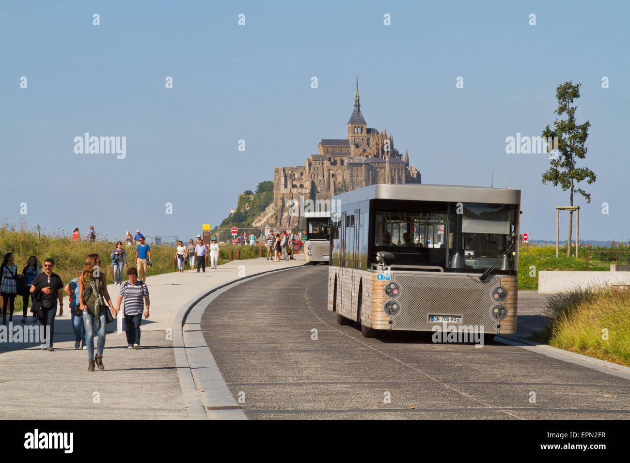 Mont St Michel les visiteurs que les traversiers de bus de touristes de l'aire de stationnement à l'abbaye, via le nouveau pont construit en 2014, la Normandie Banque D'Images