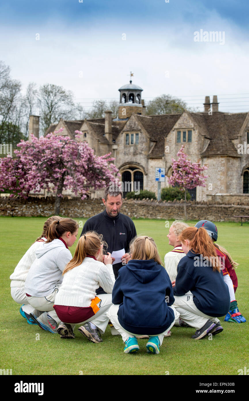 Junior Filles Se préparer pour une partie de cricket avec leur entraîneur dans le Wiltshire, Angleterre Banque D'Images