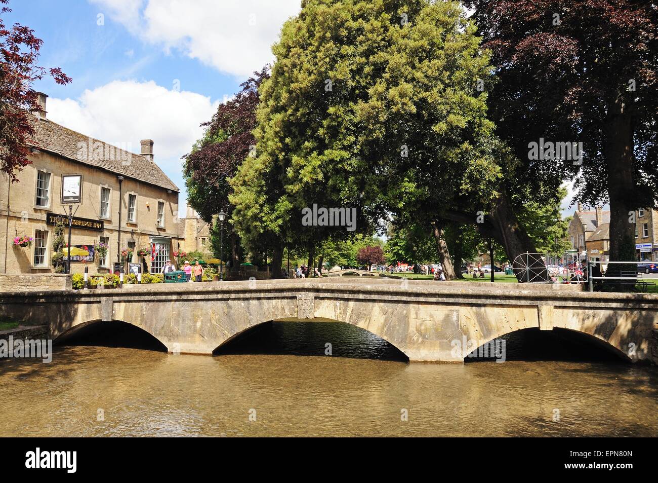 Passerelle en pierre de l'autre côté de la rivière Windrush avec l'Kingsbridge Inn à l'arrière, Bourton On The Water, Gloucestershire, Angleterre, Banque D'Images