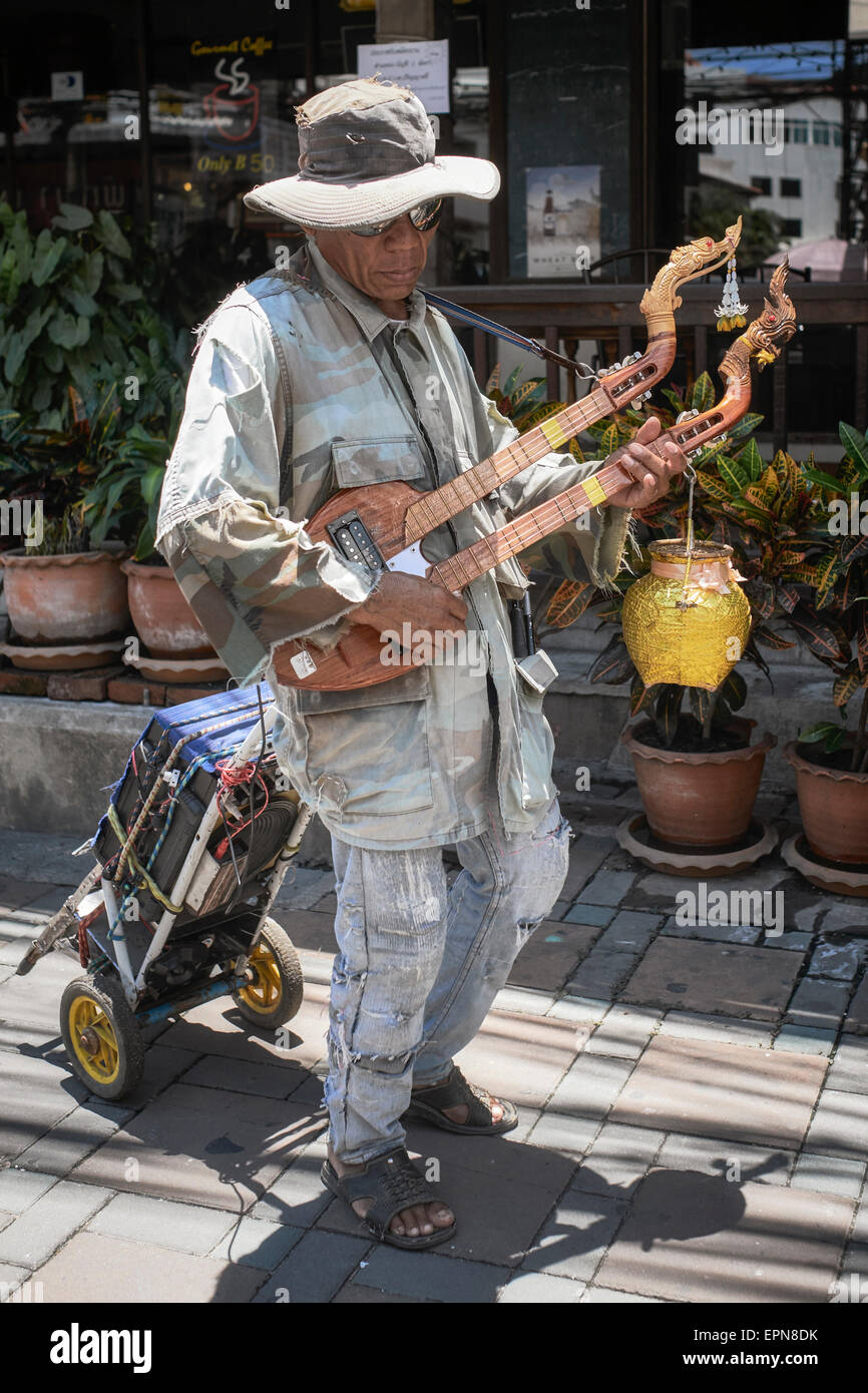 Bustier. Un buker de rue aveugle en Thaïlande jouant à la guitare traditionnelle à double cou Phin lute. Banque D'Images