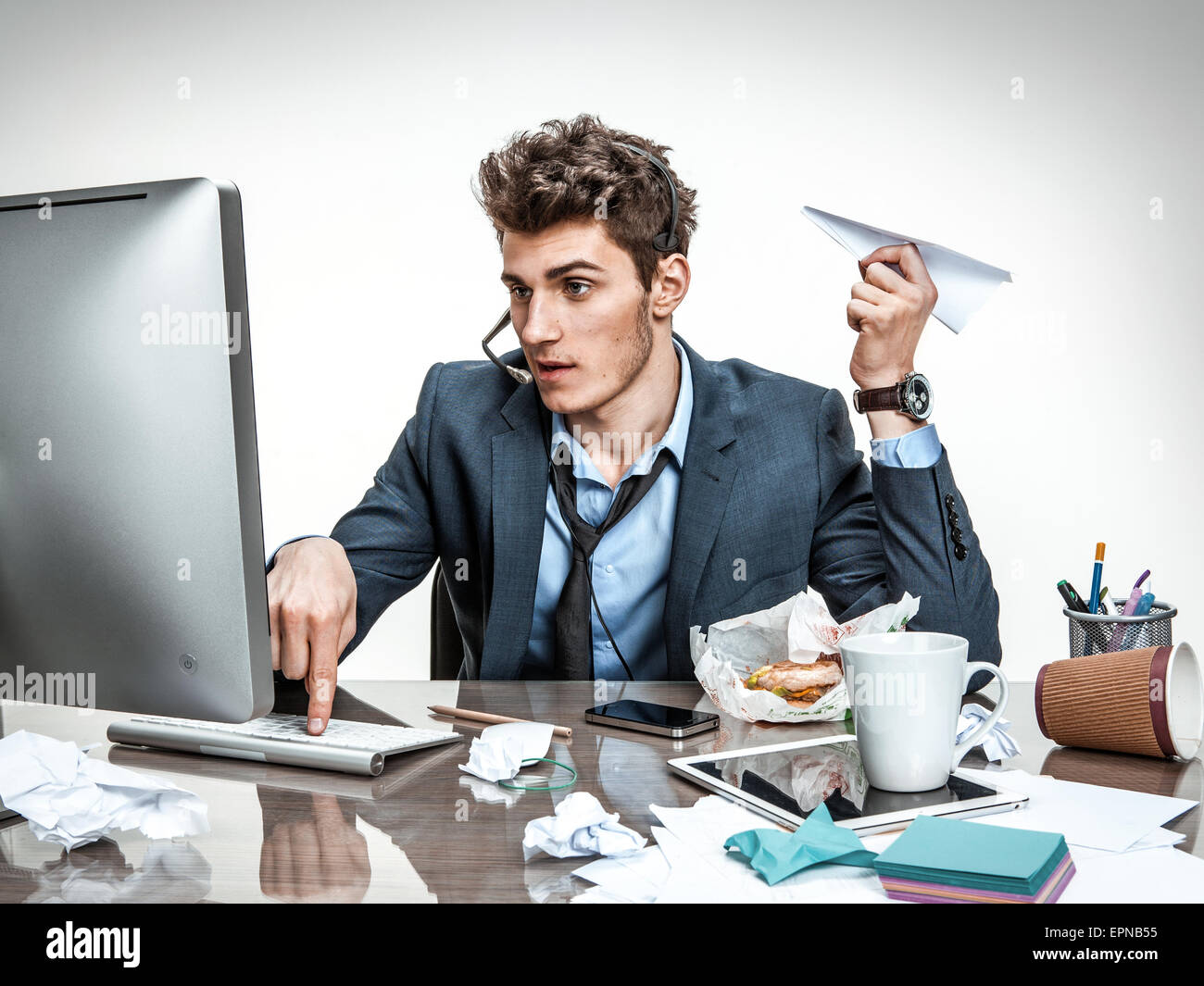 Office worker with paper plane dans sa main la saisie sur un clavier d'ordinateur Banque D'Images