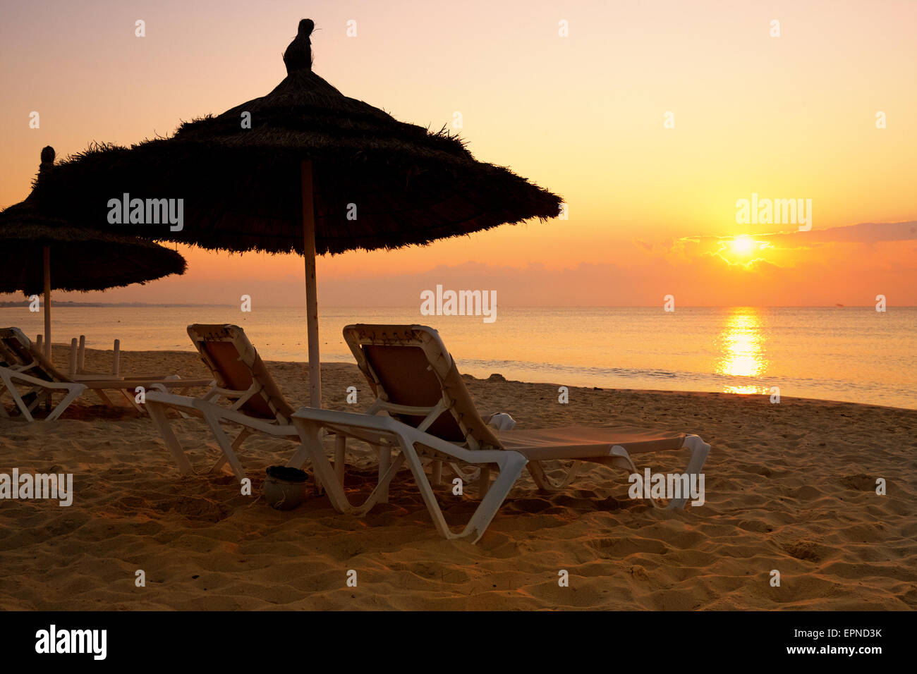 Le lever du soleil sur le parasol sur la plage, Tunisie Banque D'Images