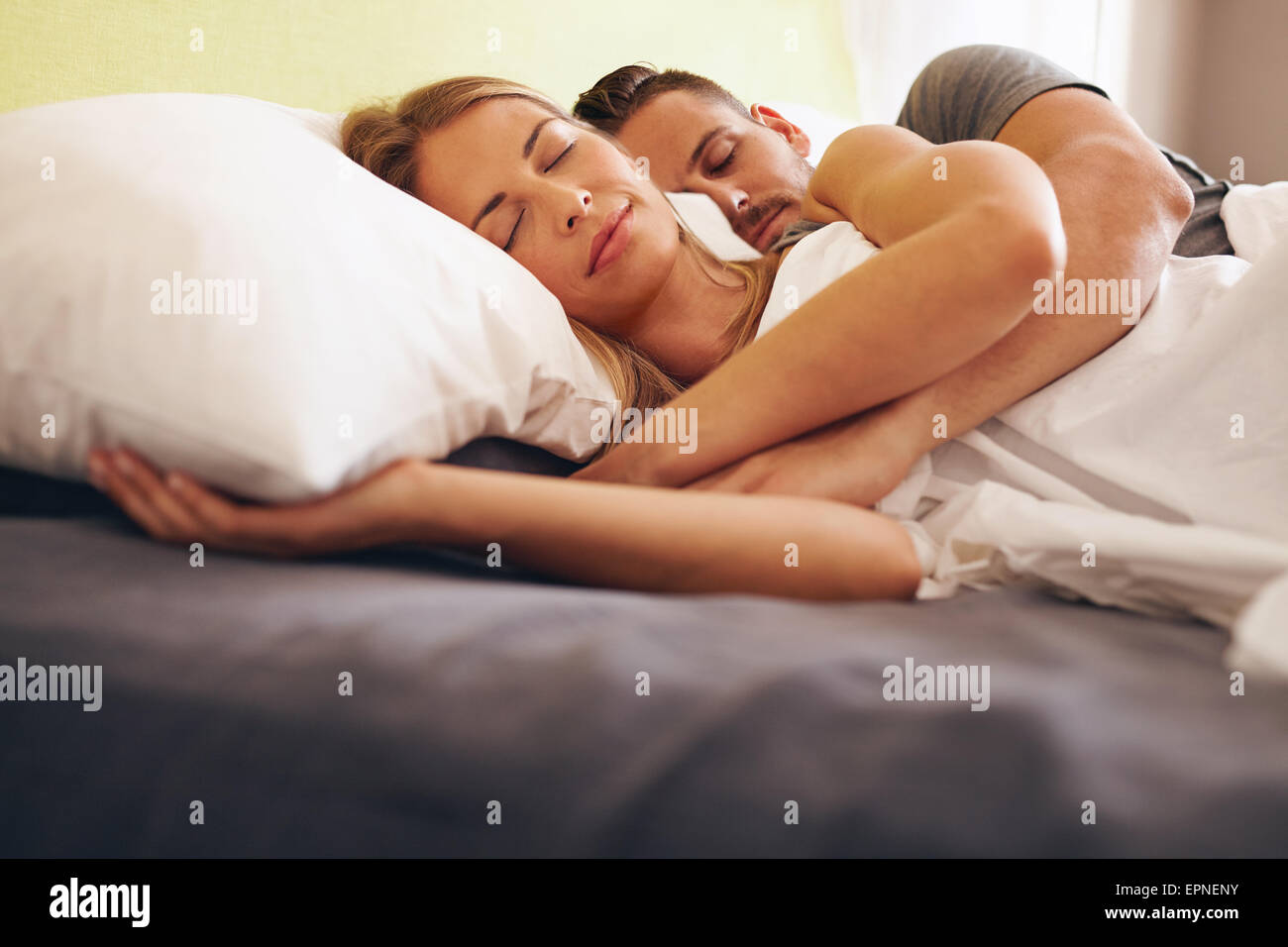 Image d'un jeune couple ensemble dormir confortablement sur le lit. Jeune homme et femme couchée endormie. Banque D'Images