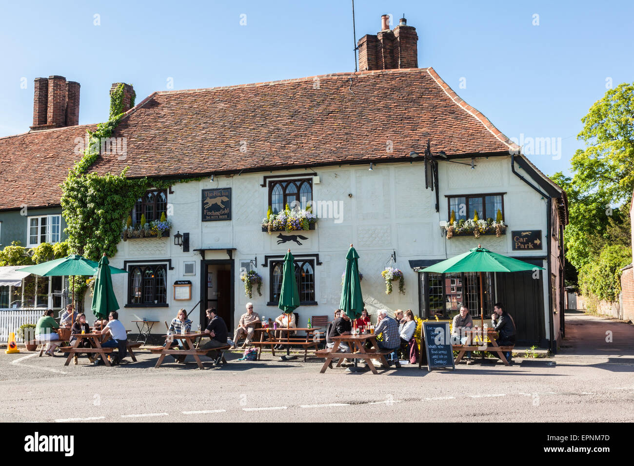 Les visiteurs de s'asseoir à l'extérieur de l'Finchingfield Fox Inn au soleil et prendre un verre, Essex, Angleterre, RU Banque D'Images