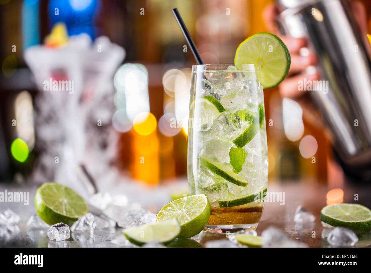 Mojito cocktail verre sur comptoir bar avec barman shaker holding on background Banque D'Images