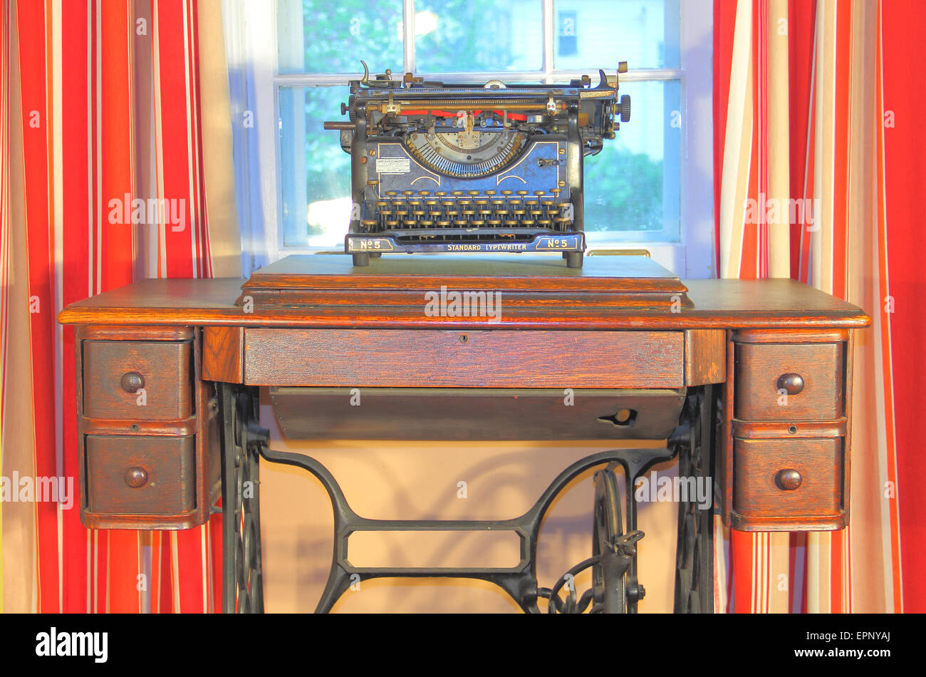 Une machine à écrire vintage sur un bureau avec des rideaux rouges Banque D'Images