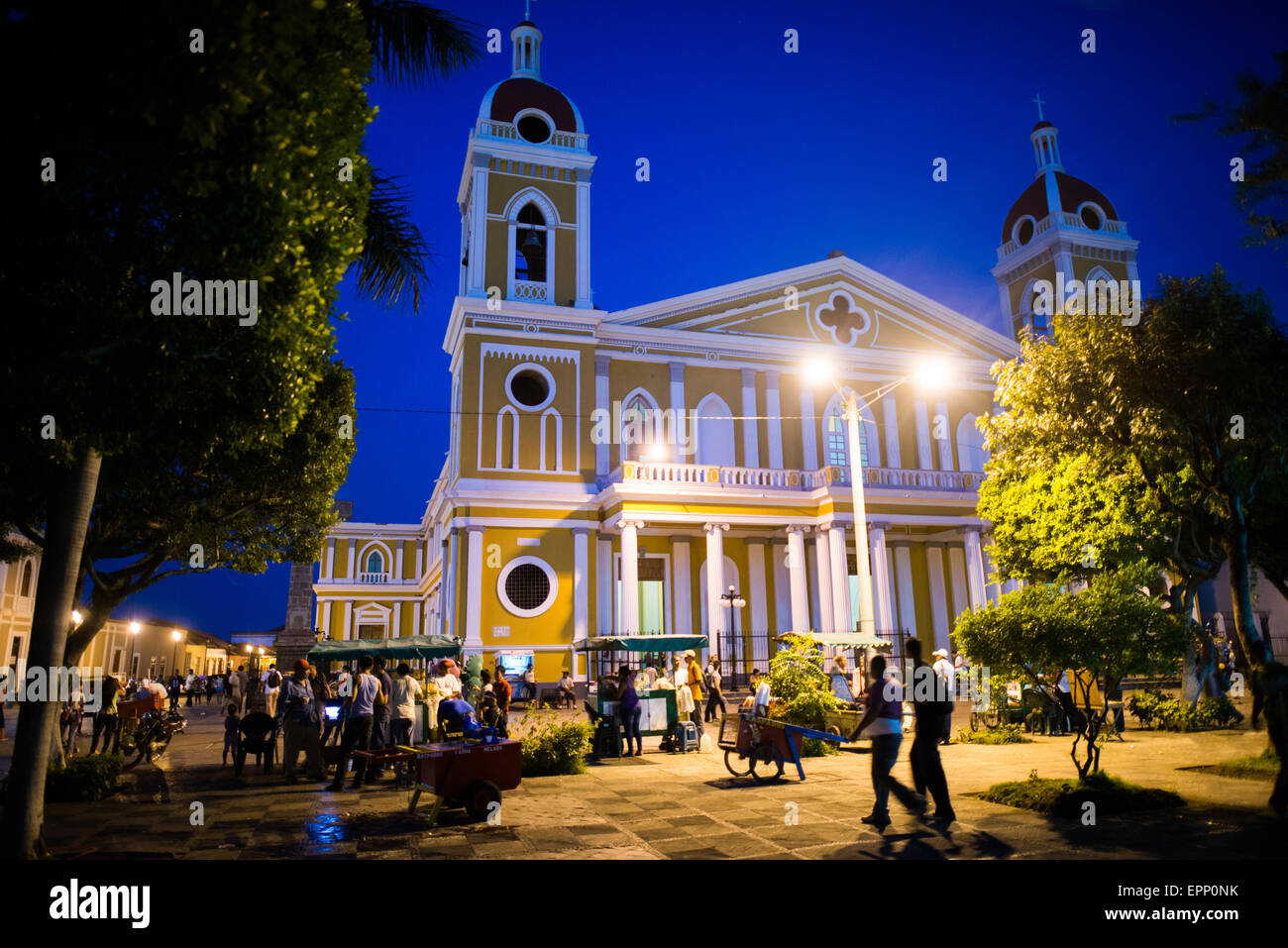 GRENADE, Nicaragua — la cathédrale de Grenade, avec son extérieur jaune et blanc distinctif, domine l'horizon du Parque Central. Il y a une église à cet endroit depuis environ 1525, mais elle a été détruite et reconstruite à plusieurs reprises dans les siècles suivants lorsque la ville de Grenade a été attaquée par des pirates et d'autres. La construction de la version actuelle a commencé en 1888, mais n'a pas été complètement achevée avant 1972. Avec son extérieur jaune distinctif avec garniture blanche, il se dresse au-dessus du Parque Central au cœur de Grenade, Nicaragua. Banque D'Images