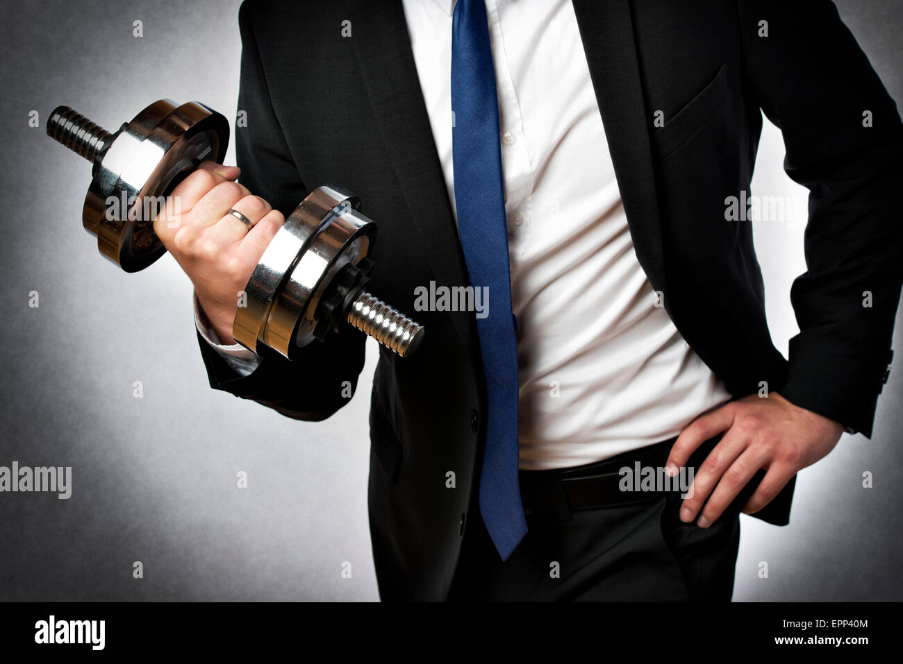 Image d'un homme d'affaires avec costume foncé et argent dumbbell Banque D'Images