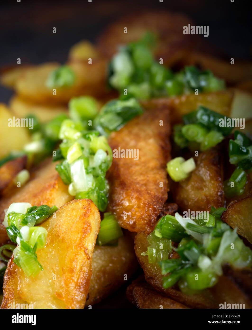 Des quartiers de pommes de terre frites croustillantes avec de l'ail vert Banque D'Images