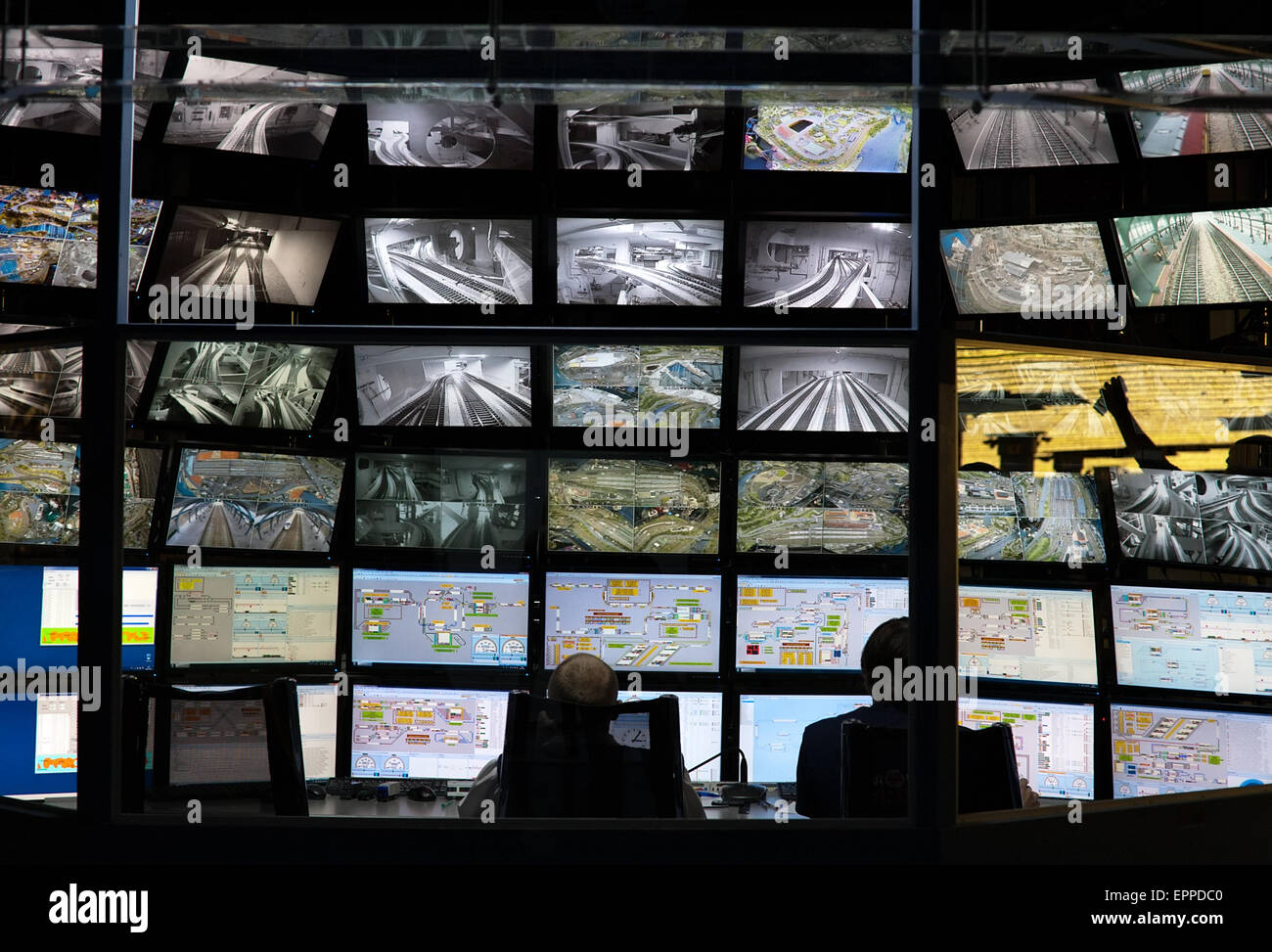 La console de commande de surveillance de la sécurité avec un mur d'écrans et deux travailleurs silhouettes retour Banque D'Images