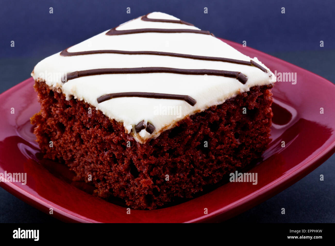 Red Velvet Cake Avec Glacage Blanc Et Bruine Legere De Chocolat Mis Sur Place Plaque Rouge Sur Fond Noir Photo Stock Alamy