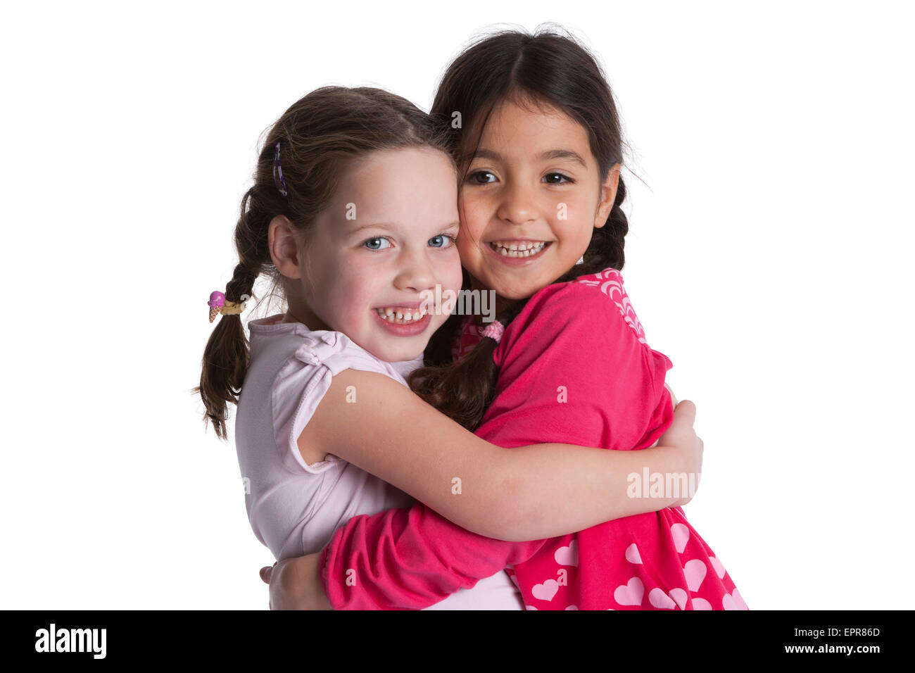 Portrait of a deux heureux fille de cinq ans friends hugging sur fond blanc Banque D'Images