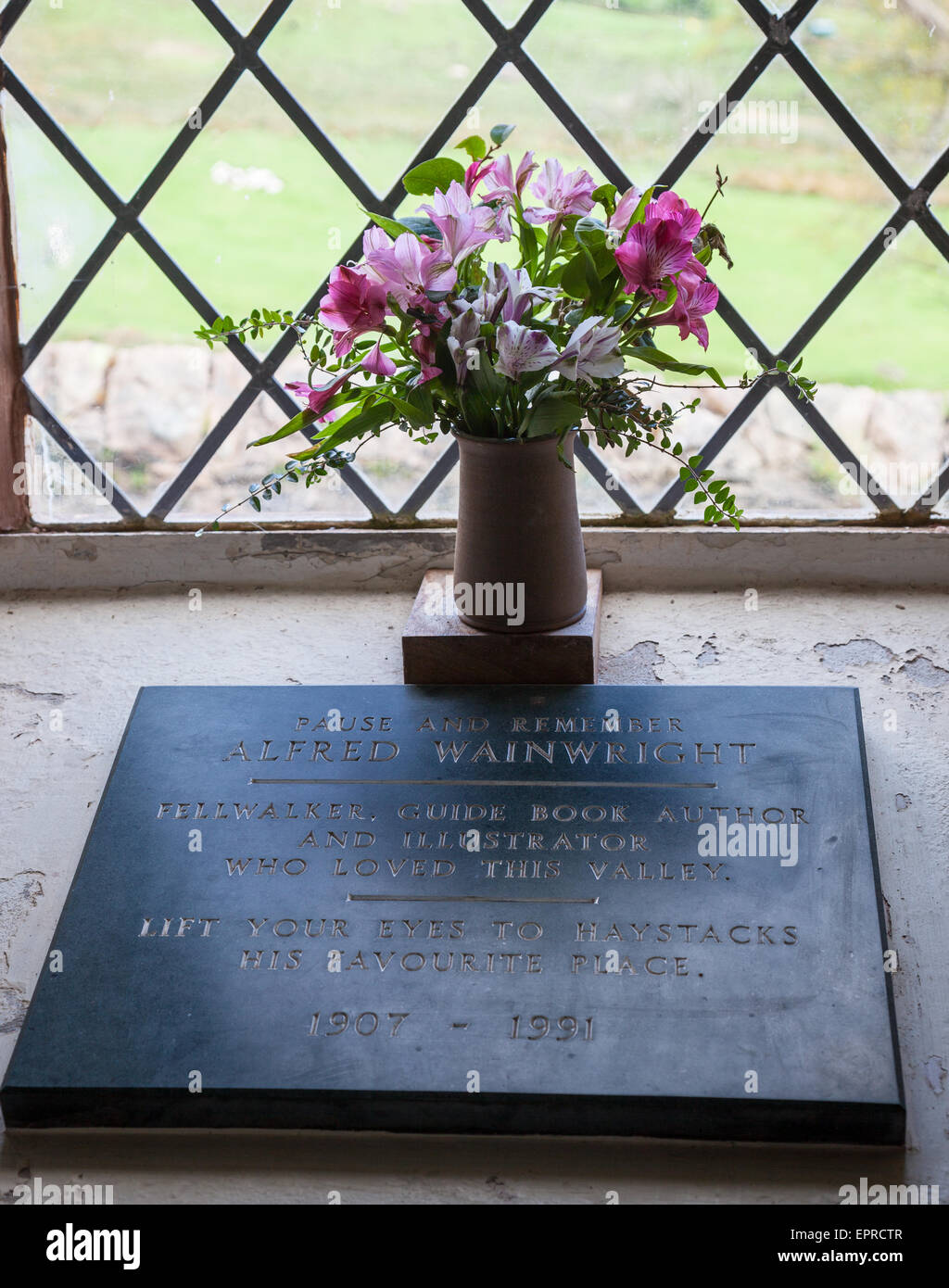 La plaque commémorative et de fleurs à Alfred Wainwright à St James' Church, Buttermere, Lake District, Cumbria Banque D'Images