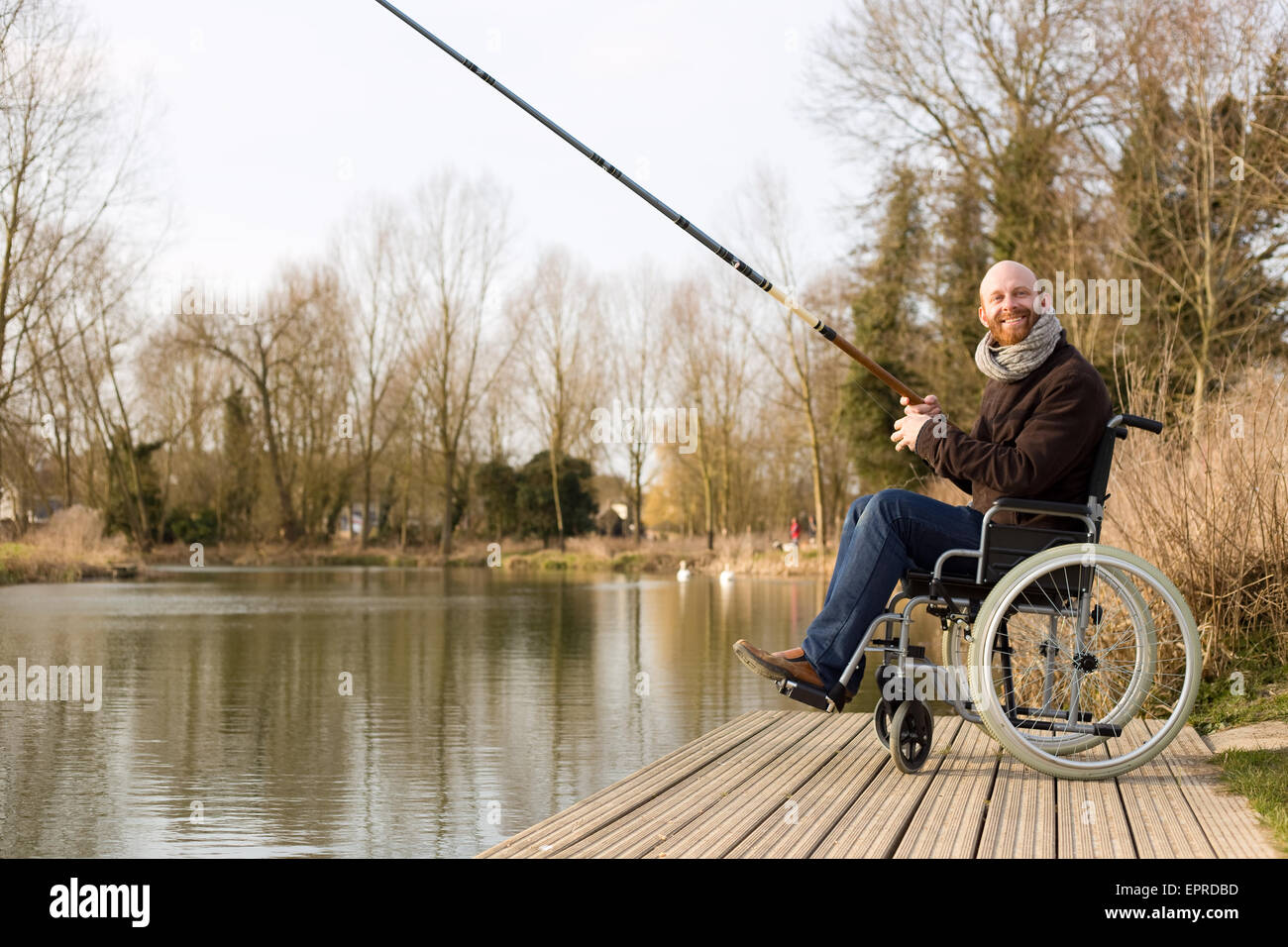 Jeune homme en fauteuil roulant la pêche Banque D'Images