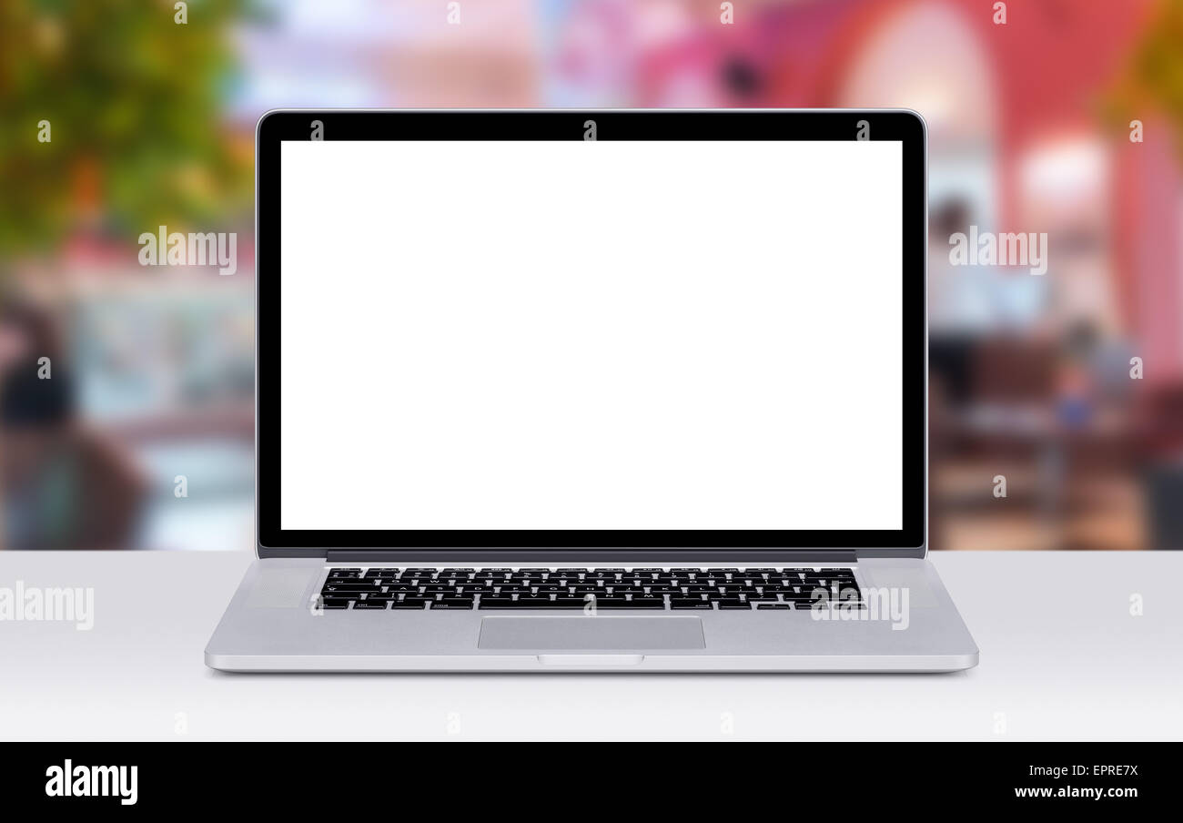 Vue avant de l'ordinateur portable moderne immersive avec blanc écran vide sur le bureau. Café Restaurant à l'arrière-plan. Banque D'Images