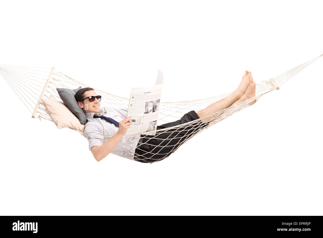 Ambiance jeune homme lisant un journal et couché dans un hamac confortable isolé sur fond blanc Banque D'Images
