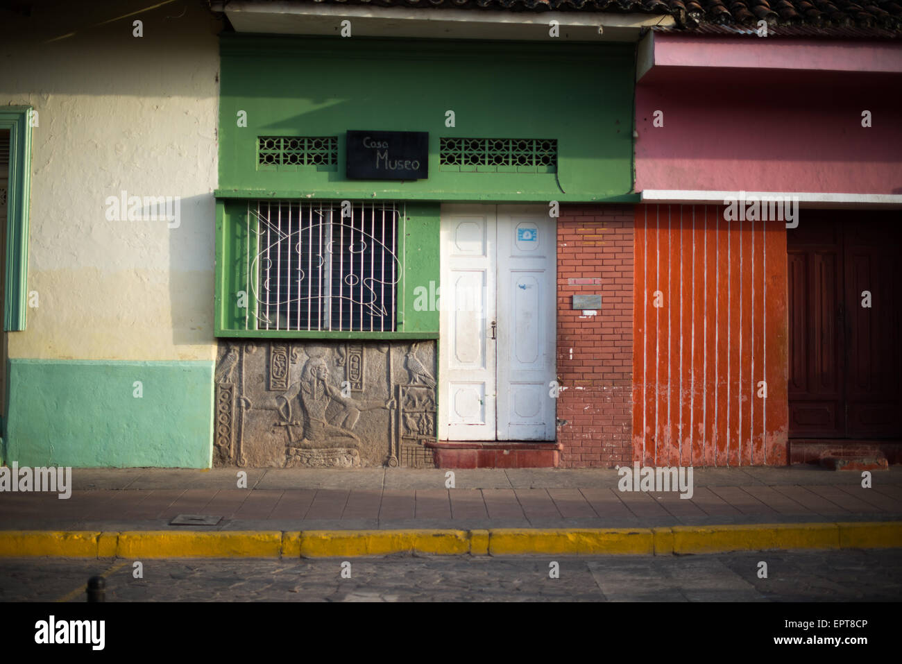 Calle la Calzada Colonial architecture Granada Nicaragua // GRANADA, Nicaragua — les façades vibrantes et colorées des commerces bordent Calle la Calzada, l'une des artères les plus populaires de Grenade. Cette rue piétonne est le cœur commercial et social de la ville coloniale, avec de nombreux magasins, restaurants et cafés installés dans des bâtiments historiques restaurés. Calle la Calzada relie le centre-ville au lac Nicaragua et est connue pour son architecture coloniale espagnole datant du XVIe siècle. Les couleurs vives des extérieurs du bâtiment illustrent la caractéristique Banque D'Images