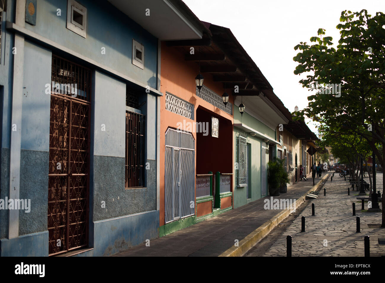 Calle la Calzada Colonial architecture Granada Nicaragua // GRANADA, Nicaragua — les façades vibrantes et colorées des commerces bordent Calle la Calzada, l'une des artères les plus populaires de Grenade. Cette rue piétonne est le cœur commercial et social de la ville coloniale, avec de nombreux magasins, restaurants et cafés installés dans des bâtiments historiques restaurés. Calle la Calzada relie le centre-ville au lac Nicaragua et est connue pour son architecture coloniale espagnole datant du XVIe siècle. Les couleurs vives des extérieurs du bâtiment illustrent la caractéristique Banque D'Images