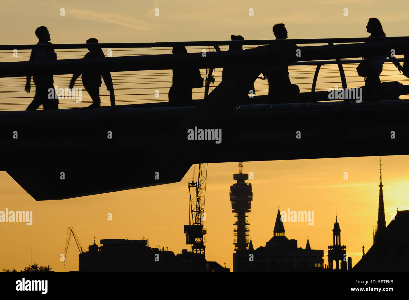 Les piétons en silhouette sur le Millennium Bridge, London UK, au crépuscule, avec des bâtiments en arrière-plan Banque D'Images