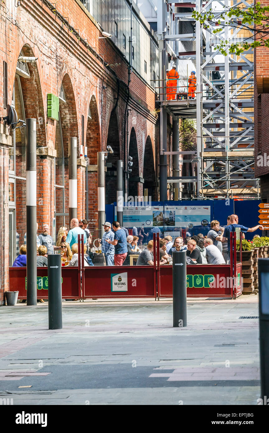 Les personnes bénéficiant d'un verre au bar Hop sous les arches de fer, Grenier à quai par Leeds et Liverpool Canal, Leeds Banque D'Images