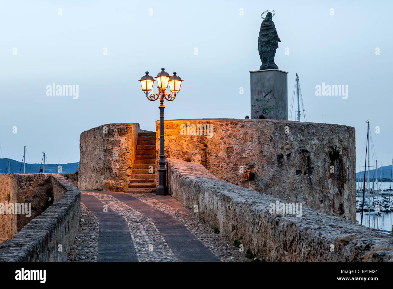 Les murs de la ville et de la statue de Jésus de nuit Alghero Sardaigne Italie Banque D'Images