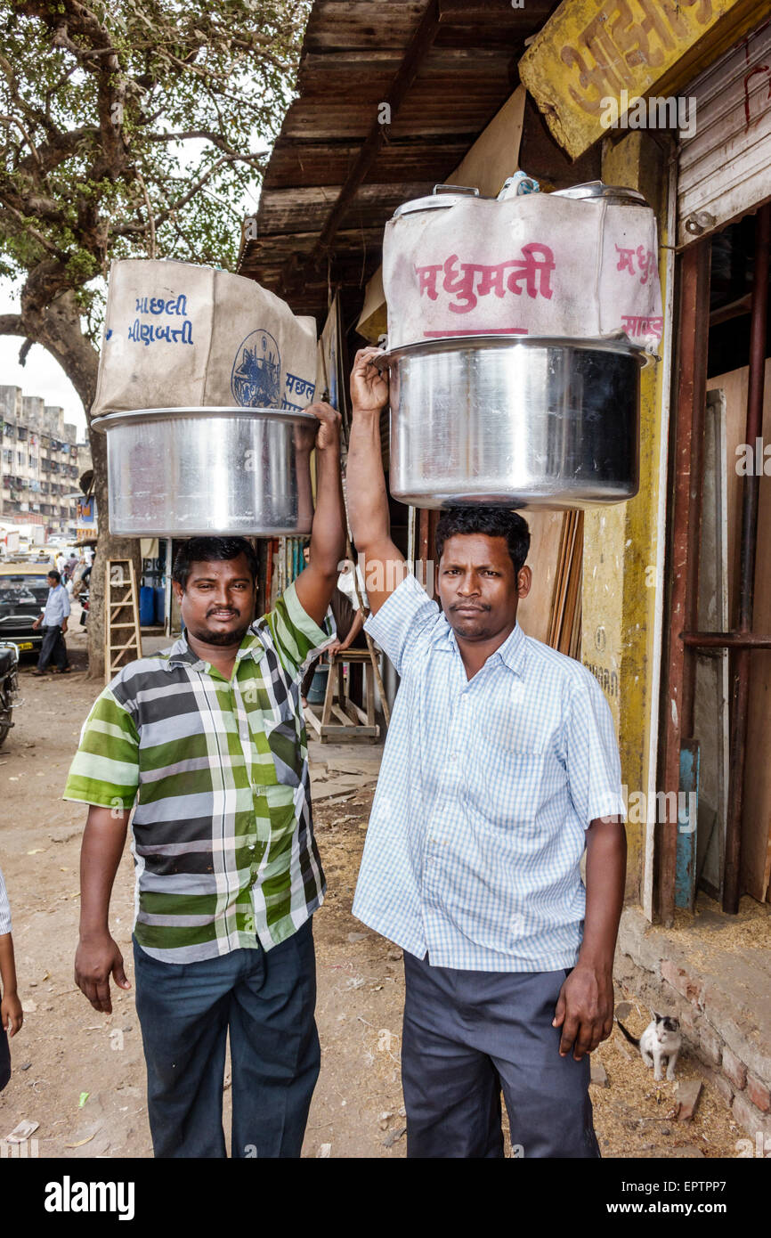 Mumbai Inde,Dharavi,60 Feet Road,taudis,faible revenu,pauvres,pauvreté,homme hommes,employés travailleurs travailleurs employés travail personnel,équilibre sur la tête,charge,pot,India1502 Banque D'Images