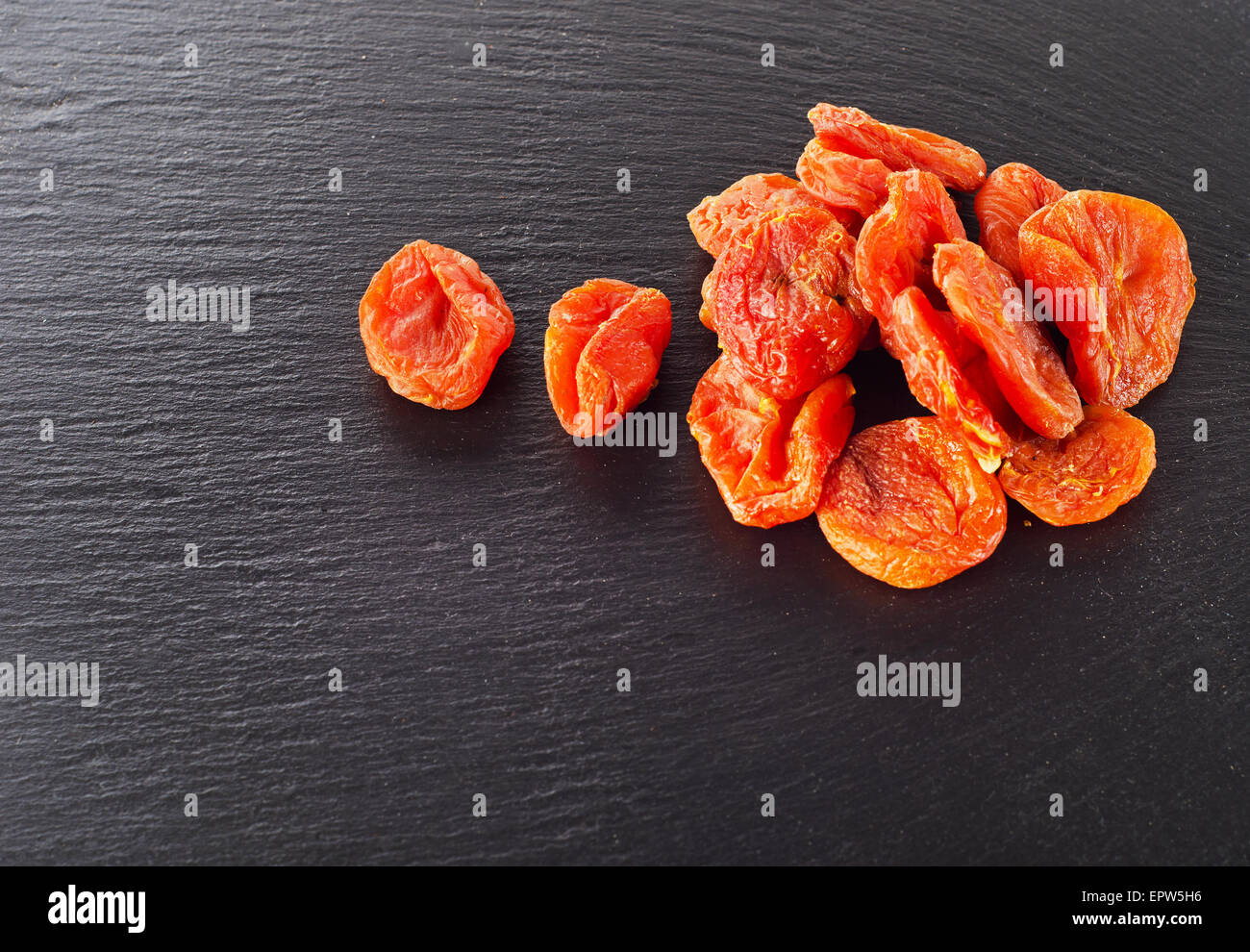 Un tas d'abricots secs sur un fond sombre. Banque D'Images