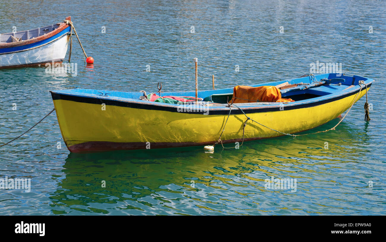 Vieux bateau à rames peintes en jaune sur l'eau le long d'une journée d'été. Banque D'Images