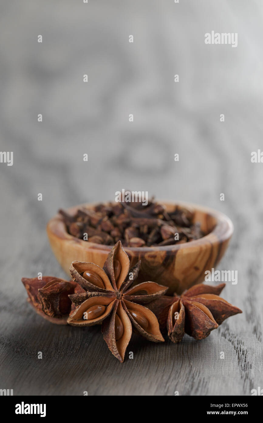 Étoiles d'anis dans un bol d'olive sur table en chêne rustique, Banque D'Images