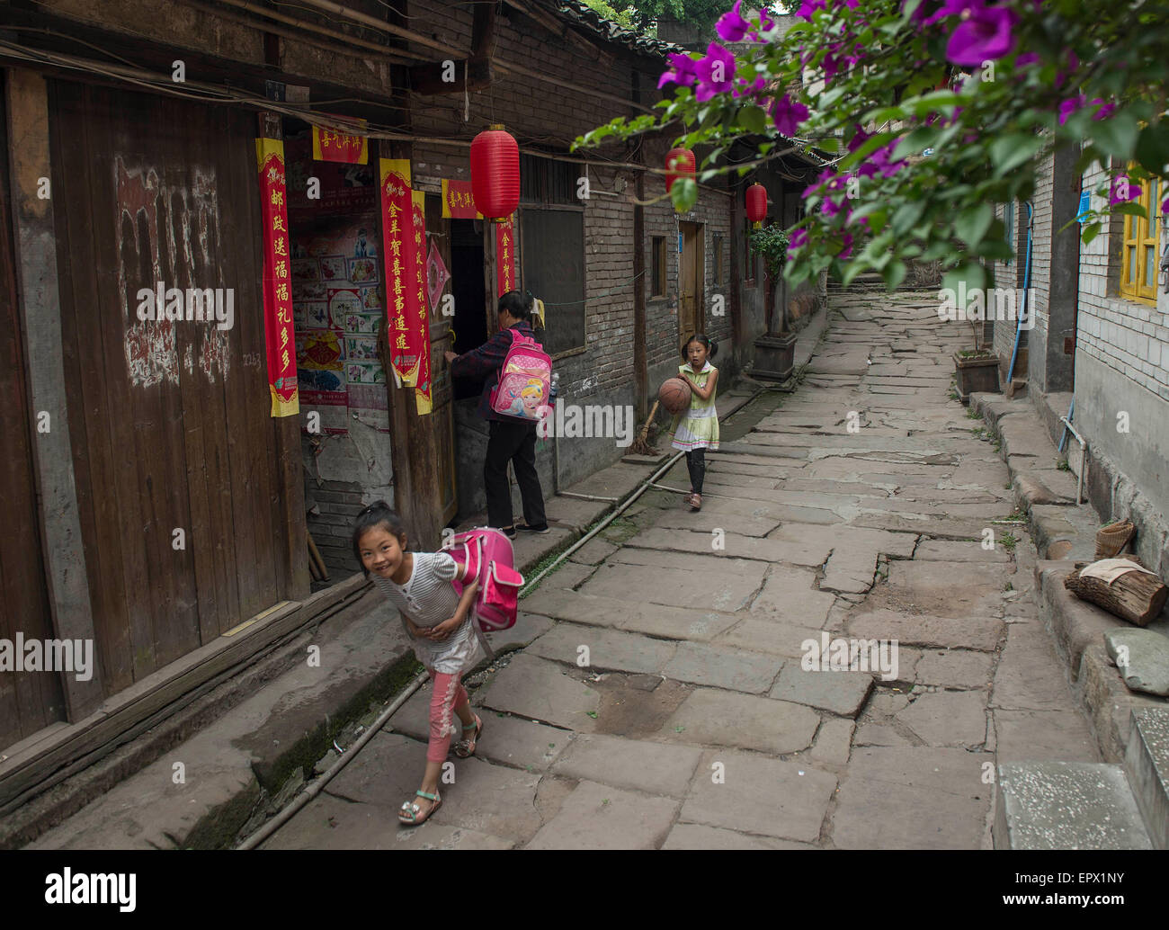 Chongqing, China's Chongqing. 22 mai, 2015. Les enfants marchent dans une ruelle dans Songji ville ancienne, au sud-ouest de la Chine Chongqing, le 22 mai 2015. La ville, située le long de la rivière Yangtze, était un lieu animé de Ming (1368-1644) et Qing (1636-1912) en raison de la dynasties des quais ici. Comme le chemin de fer et le transport routier développé dans les temps modernes, la ville tomba en décadence, mais les anciens bâtiments subsistent encore. © Chen Cheng/Xinhua/Alamy Live News Banque D'Images