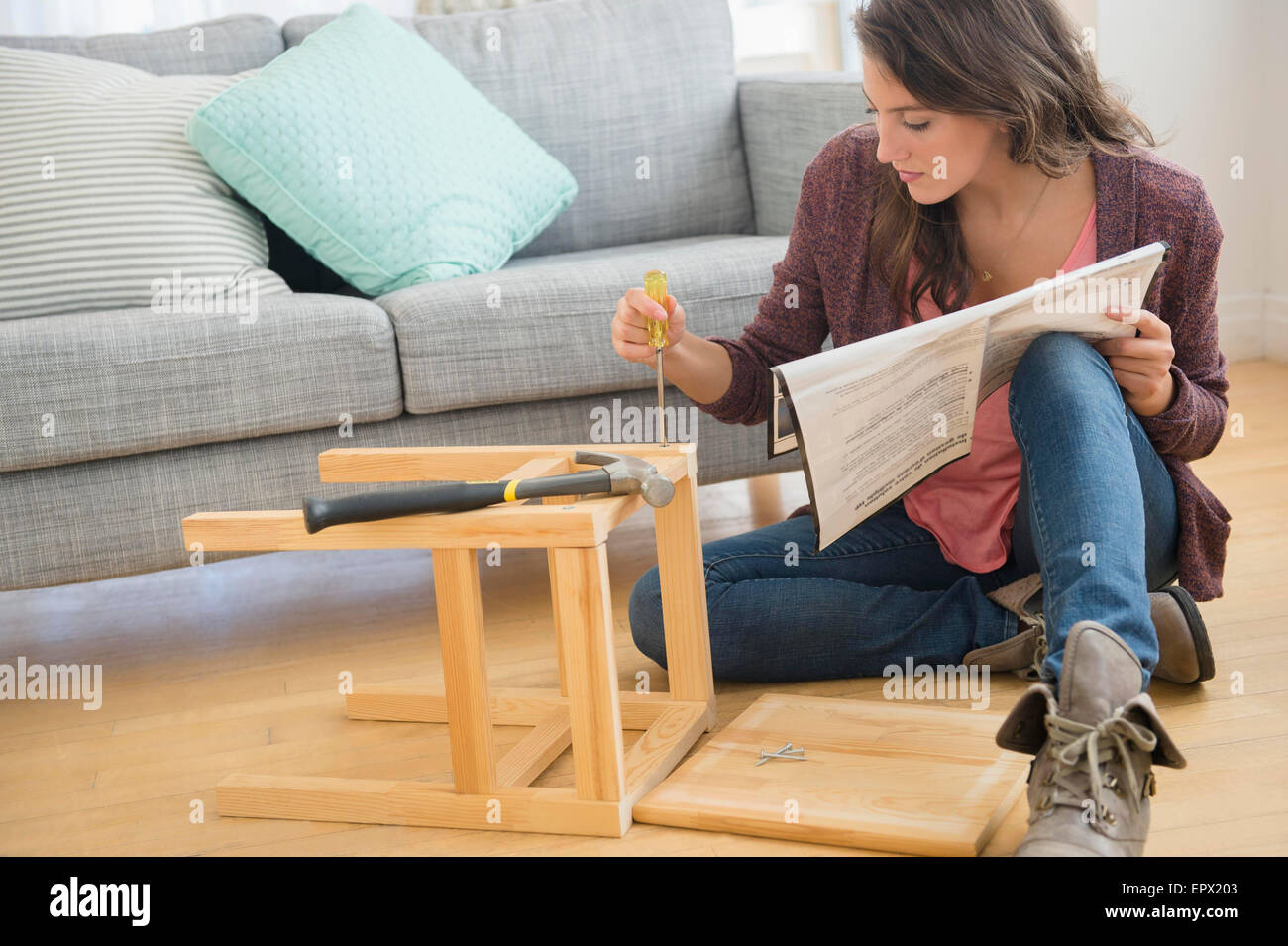 Woman putting ensemble tabouret Banque D'Images