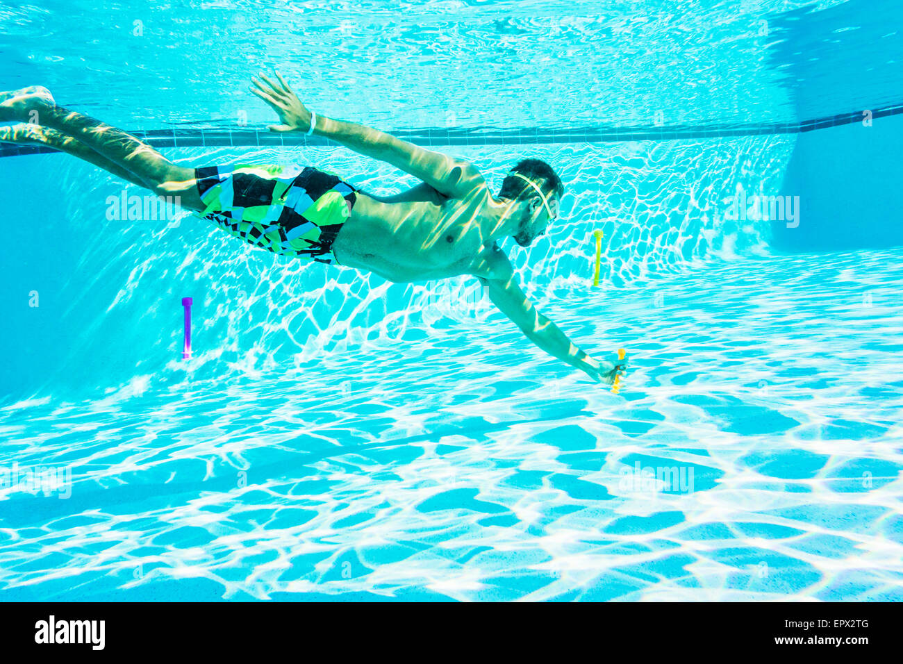 USA, Floride, Jupiter, Side-view of young man swimming in pool Banque D'Images