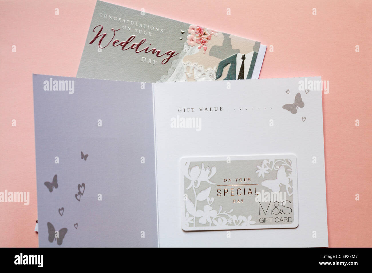 Sur votre journée spéciale M&S Carte cadeau de mariage cadeau de mariage avec card félicitations pour votre jour du mariage fixé sur fond rose Banque D'Images Sur votre journée spéciale M&S Carte cadeau de mariage cadeau de mariage avec card félicitations pour votre jour du mariage fixé sur fond rose Banque D'Images