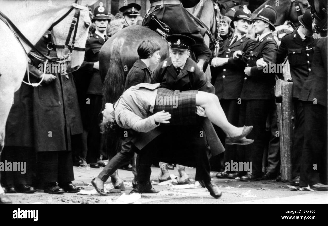 Les Beatles à Liverpool, vendredi 10 juillet 1964. Retour à l'accueil pour soirée première de "une dure journée de Nuit" à l'Odeon Cinema. Sur la photo : jeune fille s'évanouit du ventilateur à l'extérieur de l'hôtel de ville. Banque D'Images