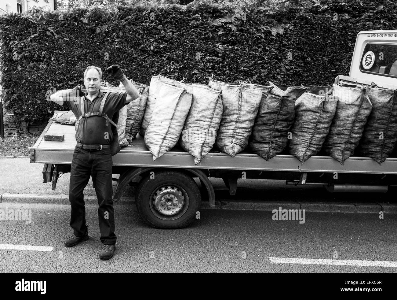 Charbon traditionnel livraison sacs homme ouvert du charbon de lorry Banque D'Images