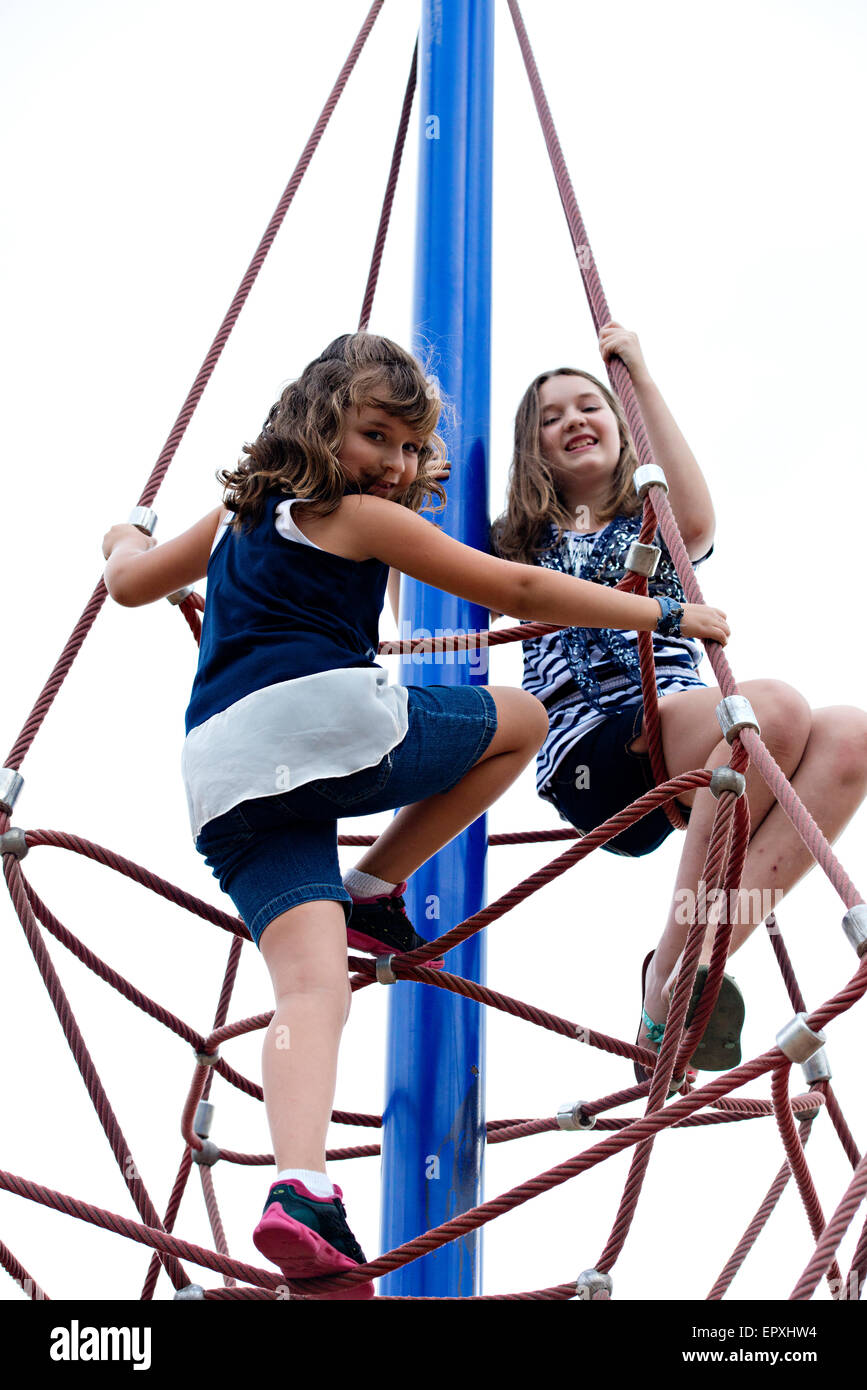 Les filles jouent sur corde à structure extérieur parc jeux pour enfants Banque D'Images