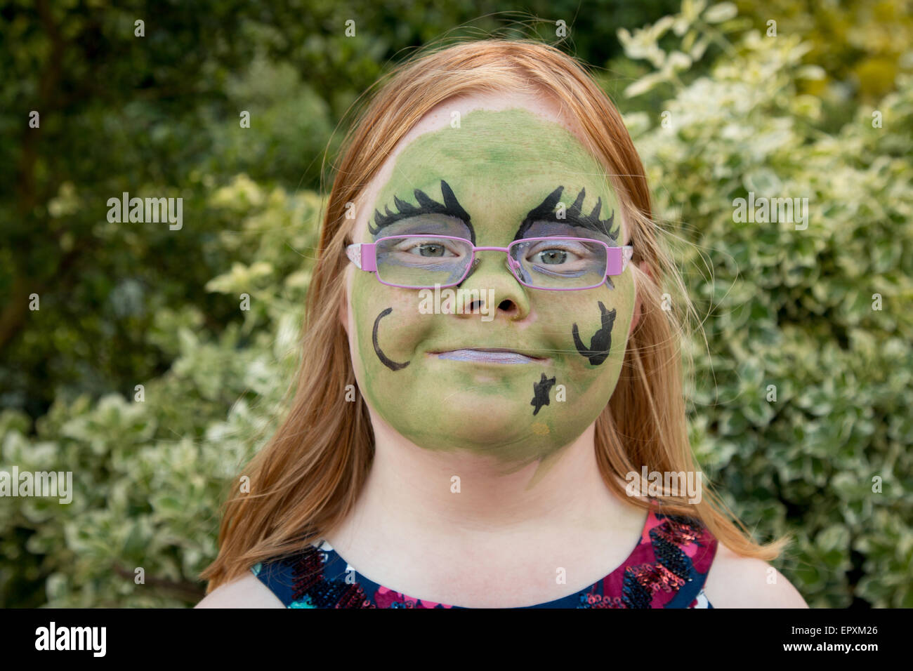 Jeune fille de 11 ans avec le syndrome de Down, avec visage peint comme une sorcière Banque D'Images