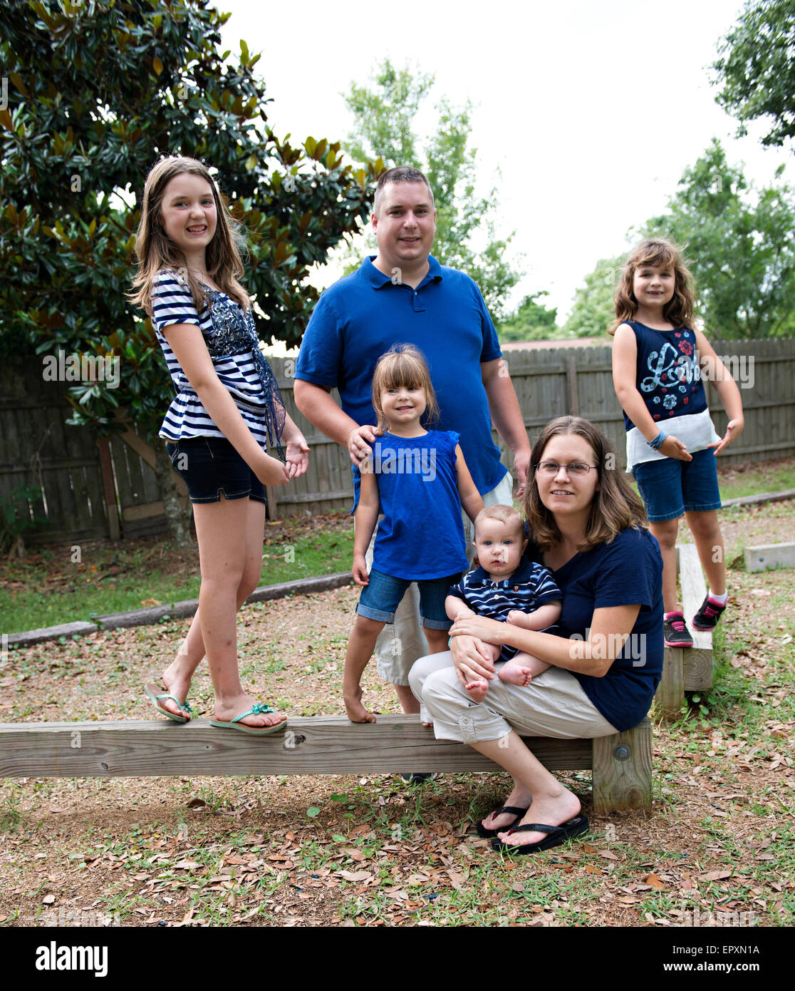 Famille qui pose pour un portrait dans une aire de stationnement en plein air Banque D'Images