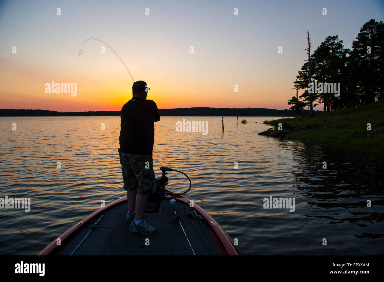 Pêcheur de proue du bateau bass la pêche de l'achigan à grande bouche à McGee Creek dans le lac Michigan au coucher du soleil. Banque D'Images