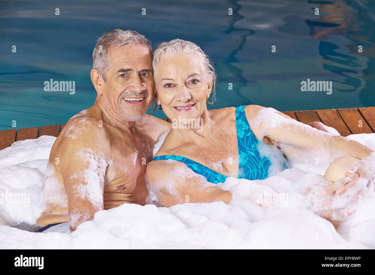 Happy senior couple prenant un bain de mousse en mousse dans un bain à remous Banque D'Images