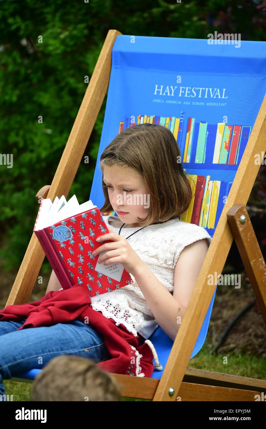 Hay-on-Wye. Pays de Galles au Royaume-Uni. Samedi 23 Mai 2015 Une jeune fille assise dans un transat, perdu dans le plaisir de lire un livre et profiter de la chaleur des rayons du soleil au festival de littérature de Hay Crédit photo : Keith morris / Alamy Live News Banque D'Images