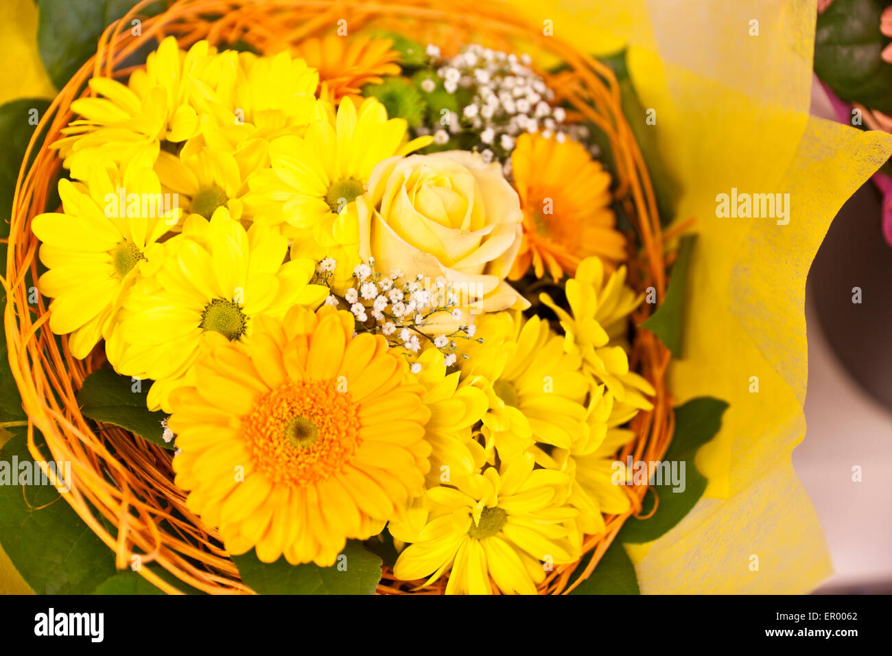 Un bouquet de gerberas jaunes et orange dans le panier Banque D'Images