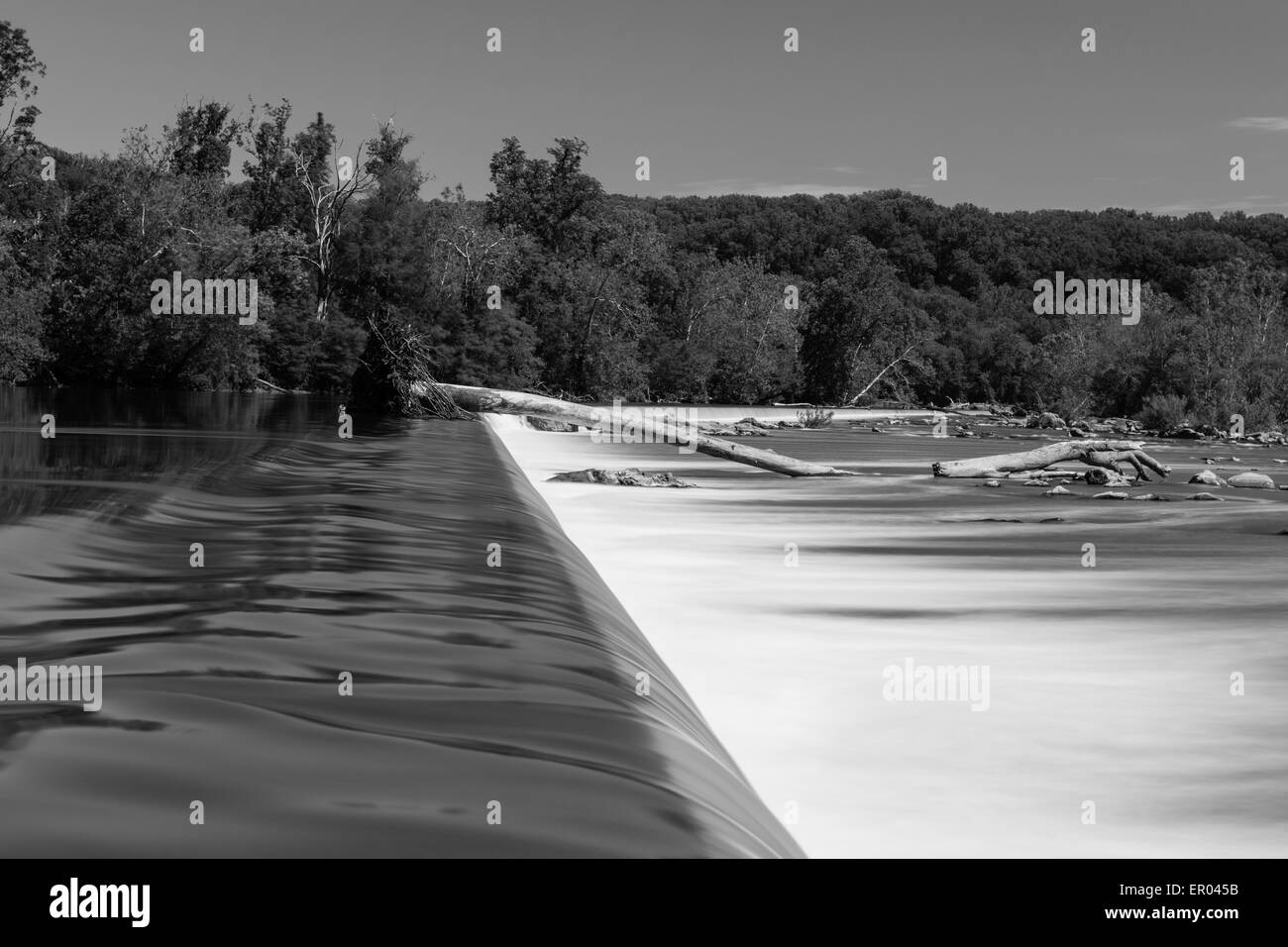 L'exposition de l'eau Long soyeux sur barrage par l'homme en noir et blanc Banque D'Images