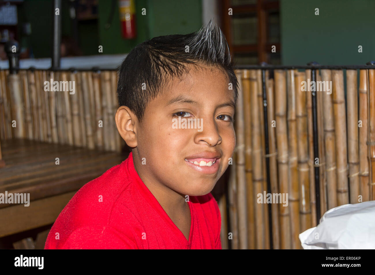 Les jeunes service de cireur garçon dans Antigua Guatemala. Il brille chaussures dans Central Park quand pas à l'école. Banque D'Images